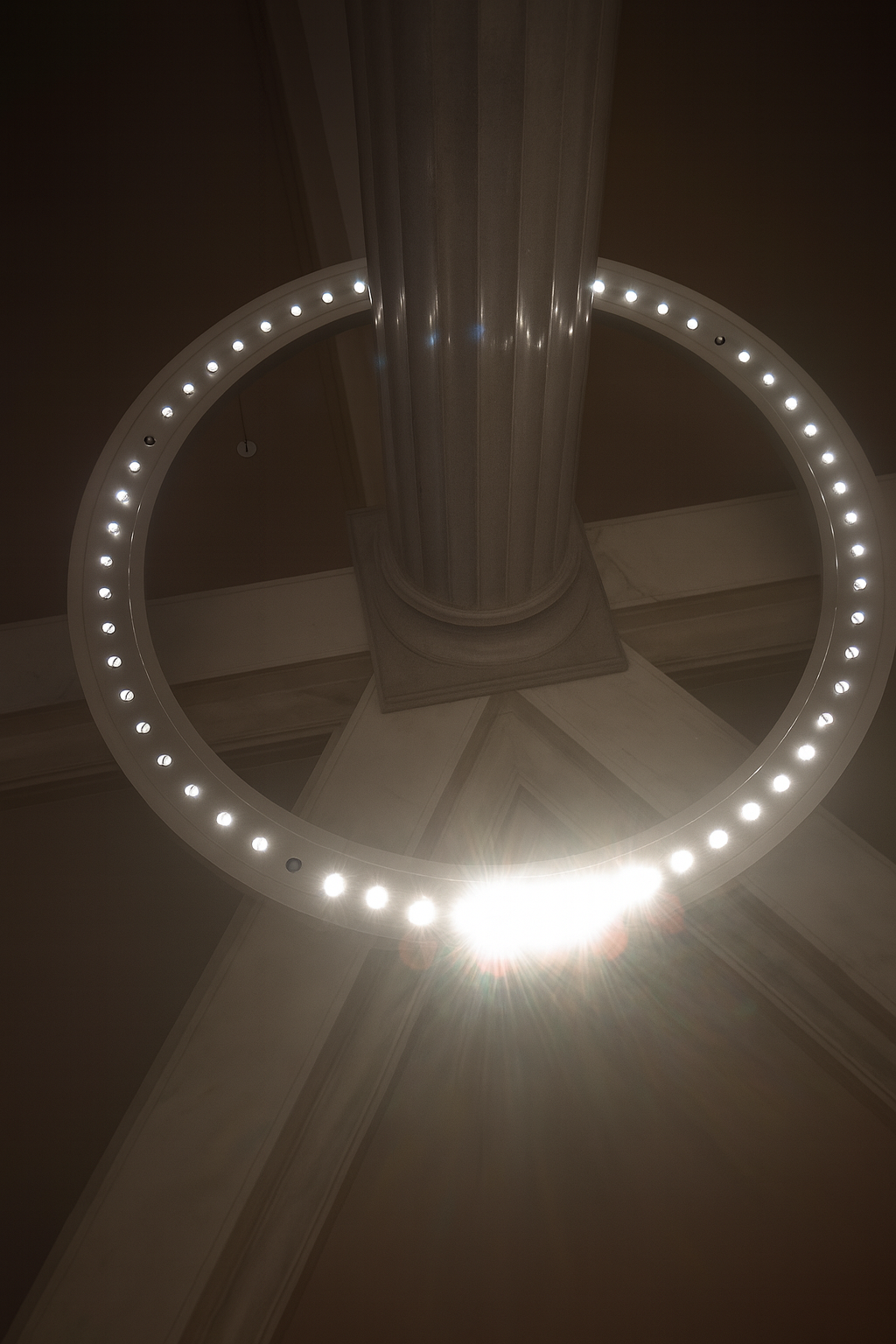 The Reliquary artwork with a glowing LED ring encircling a classical column base in darkness